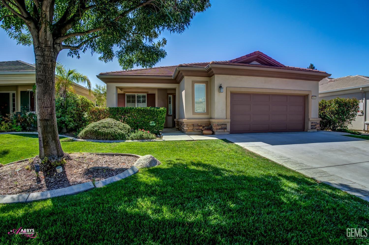 Undisclosed Address Bakersfield, CA 93306 - Photo 4 of 49 a front view of a house with a yard and garage
