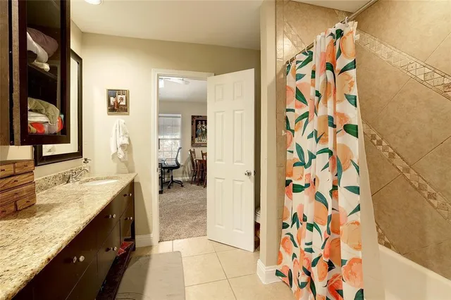 a spacious bathroom with a granite countertop sink a mirror a vanity and shower