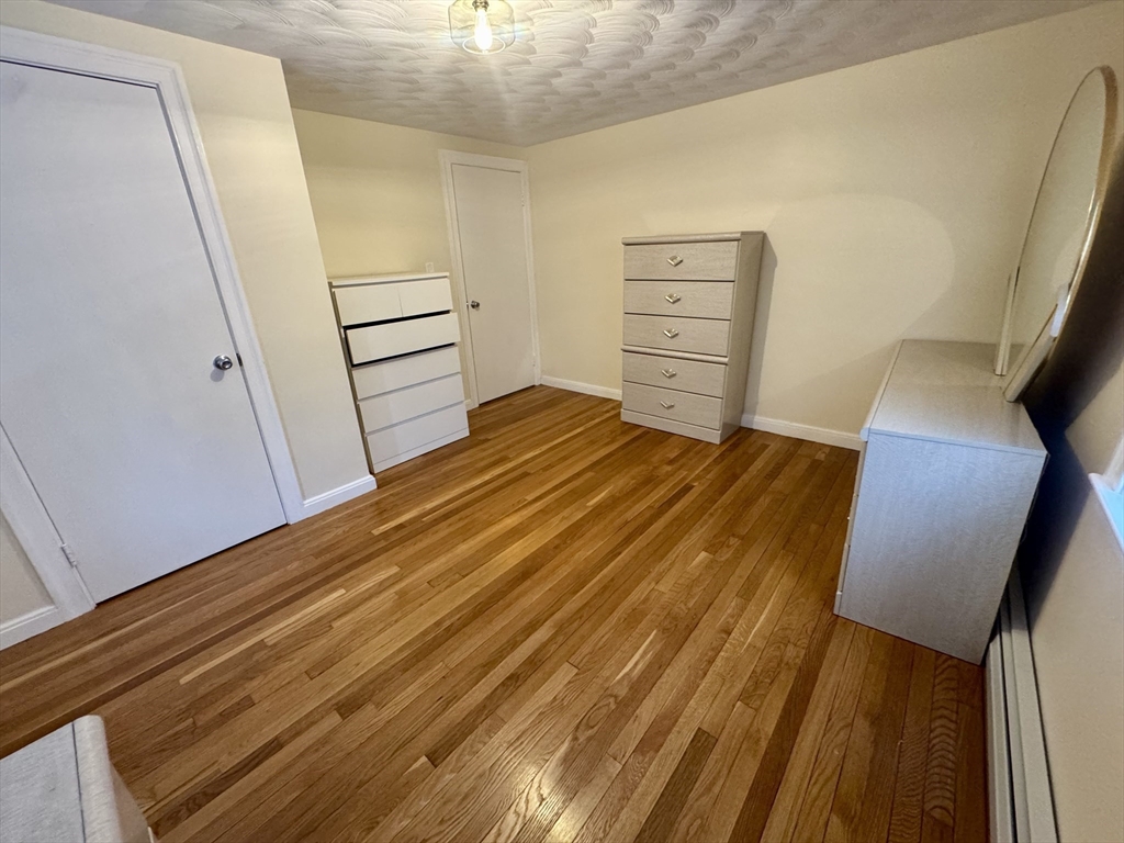 72 Redlands Road Boston, MA 02132 - Photo 21 of 31 a bedroom with a bed and wooden floor