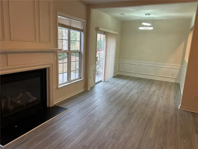 a view of a livingroom with wooden floor and a fireplace