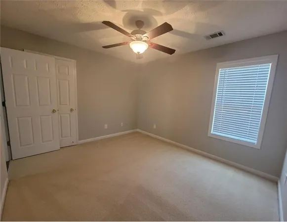 a view of an empty room with a chandelier fan