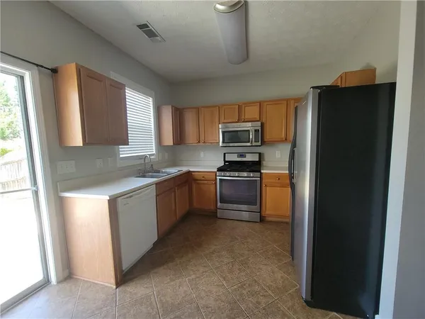 a kitchen with a refrigerator sink and cabinets