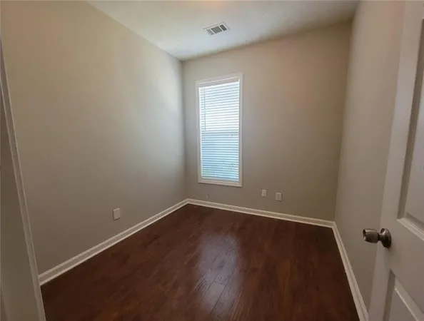 an empty room with a hardwood and a window