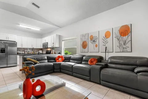 a living room with furniture a couch and kitchen view