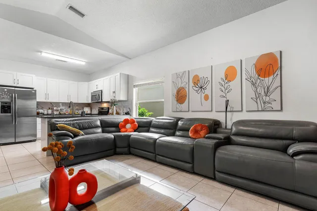 a living room with furniture a couch and kitchen view