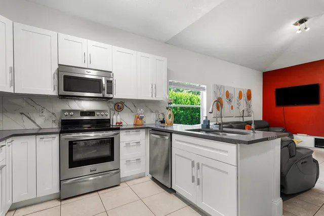 a kitchen with stainless steel appliances granite countertop a stove microwave and sink