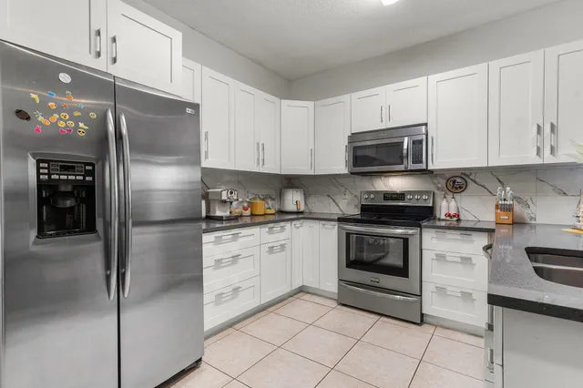 a kitchen with cabinets stainless steel appliances and a counter space