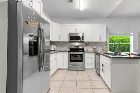 a kitchen with stainless steel appliances a refrigerator sink and microwave