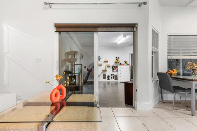 a view of a hallway with dining area and glass windows