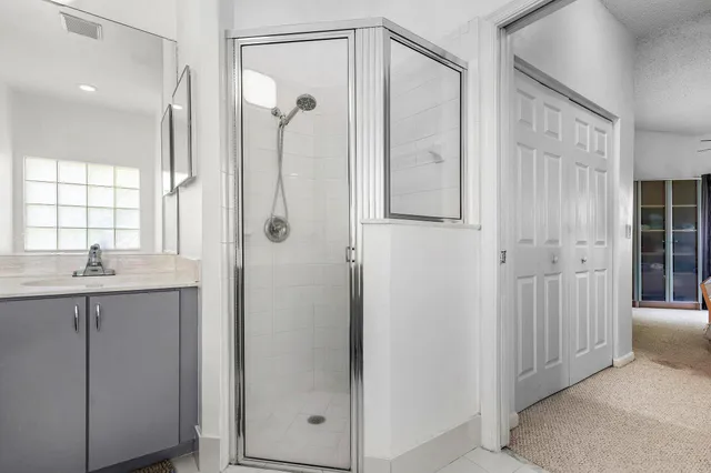a bathroom with a shower sink and mirror