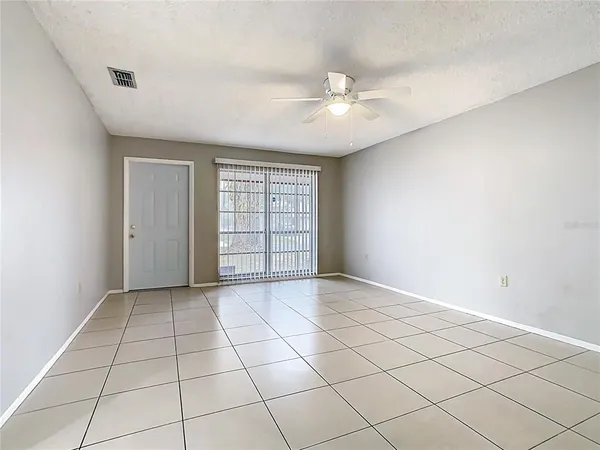 an empty room with windows and fan