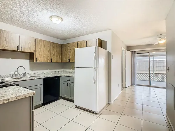 a kitchen with a refrigerator a stove top oven and cabinets