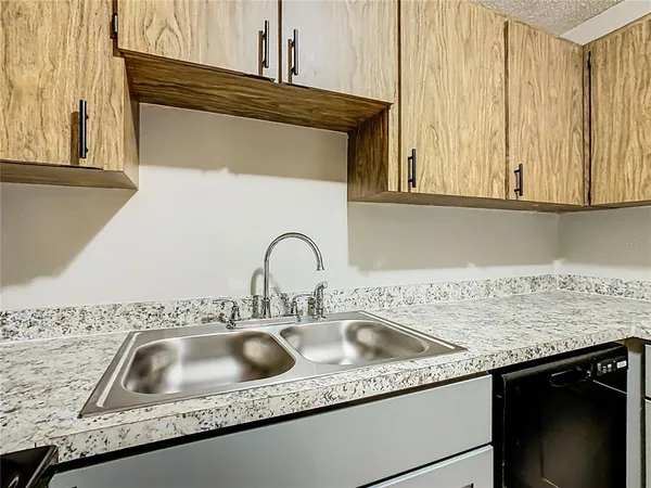 a kitchen sink with granite countertop a sink and cabinets