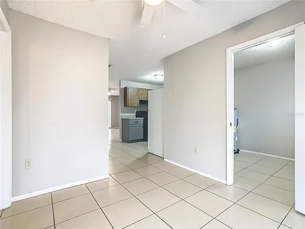 an empty room with fan and windows