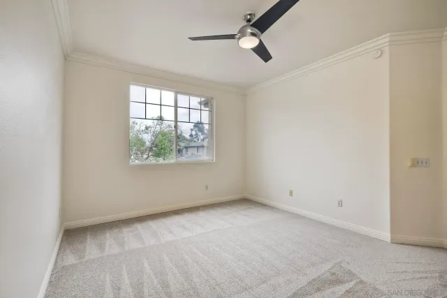 a view of an empty room with a ceiling fan