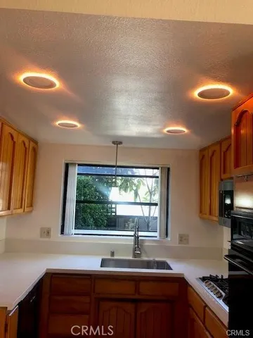 a kitchen with stainless steel appliances granite countertop a sink a stove and a window