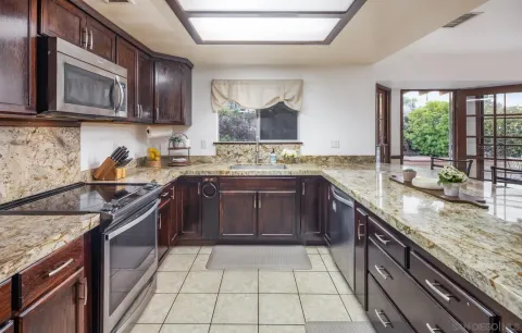 a kitchen with stainless steel appliances granite countertop a sink stove and cabinets
