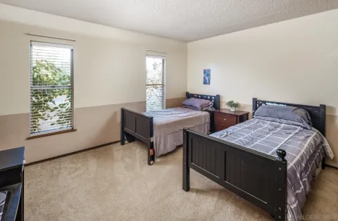 a bedroom with two beds and window