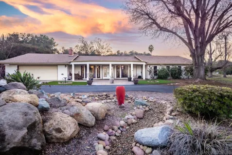 a front view of a house with a yard and green space