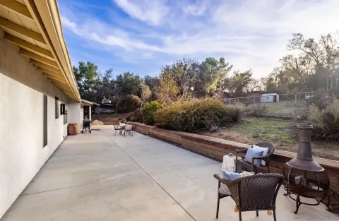 a view of a patio with couches table and chairs and potted plants