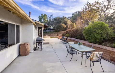 a backyard of a house with table and chairs