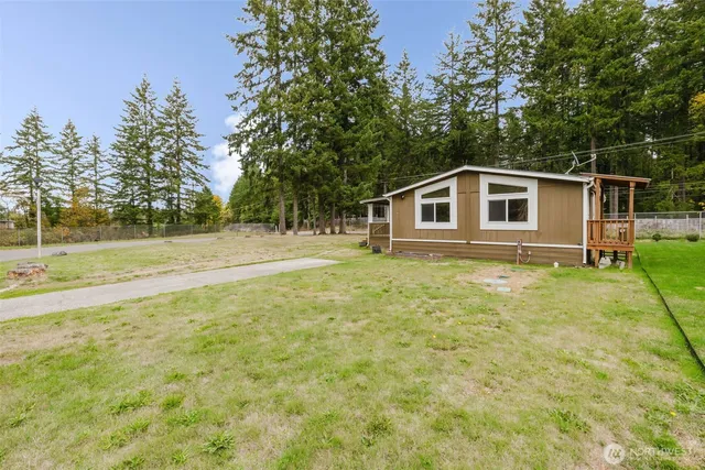 a front view of a house with a yard and trees