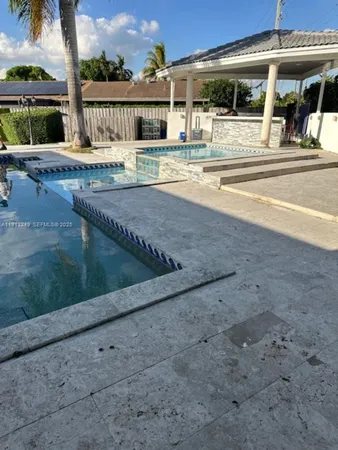 a view of a swimming pool with a lawn chairs under an umbrella