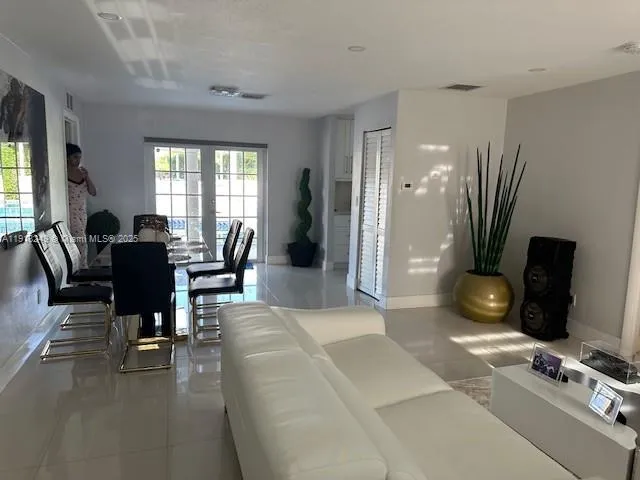 a living room with furniture a flat screen tv and a large window