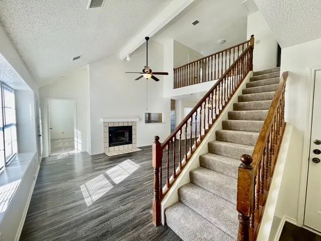 a view of staircase with wooden floor and a fireplace