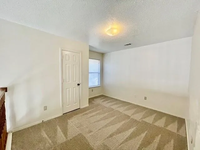 a view of an empty room with wooden floor and entryway