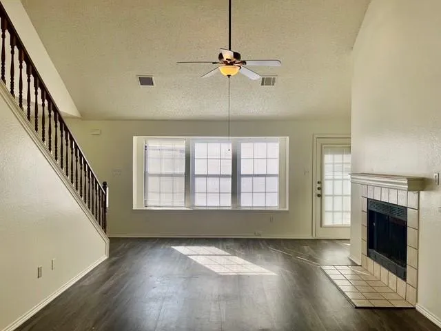 an empty room with windows and fireplace