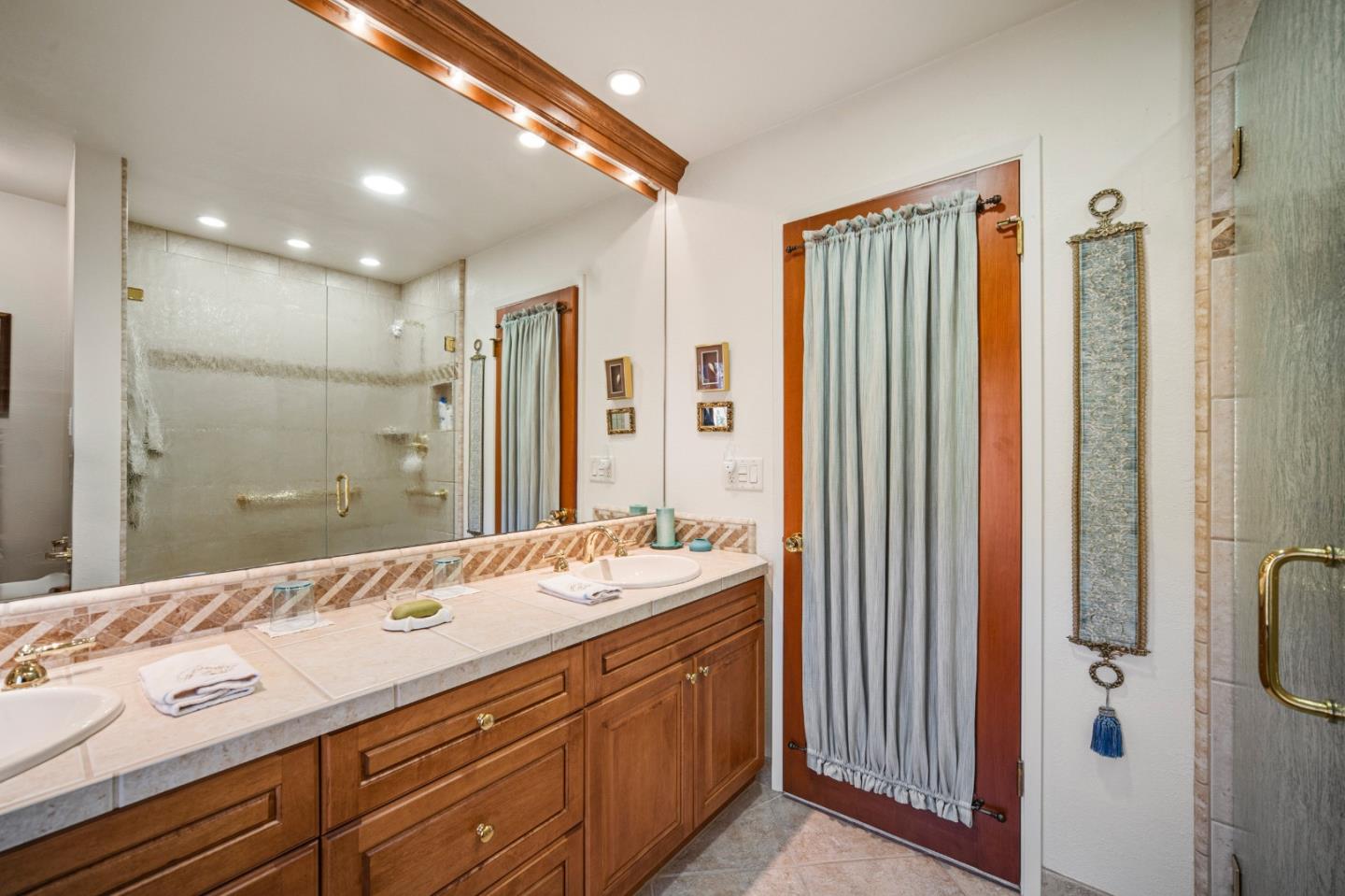 2911 Colton Road Pebble Beach, CA 93953 - Photo 32 of 46 a bathroom with a double vanity sink a mirror and a shower
