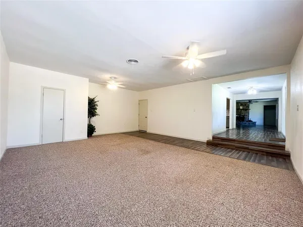 a view of a livingroom with wooden floor and furniture