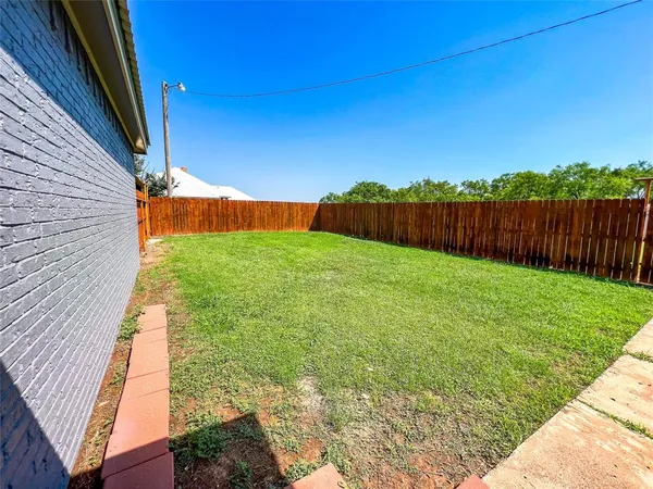 a view of a garden with wooden fence