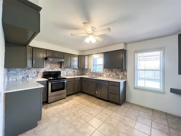 a kitchen with stainless steel appliances granite countertop a stove sink and cabinets