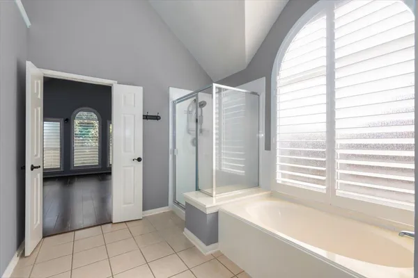 a bathroom with a tub shower and window