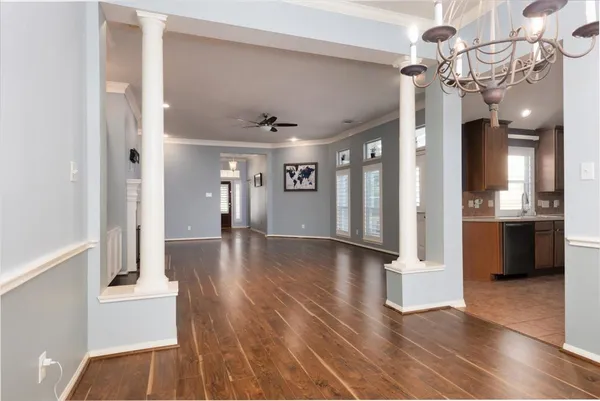 a view of a hallway with wooden floor and a living room