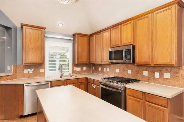a kitchen with stainless steel appliances a sink stove and cabinets