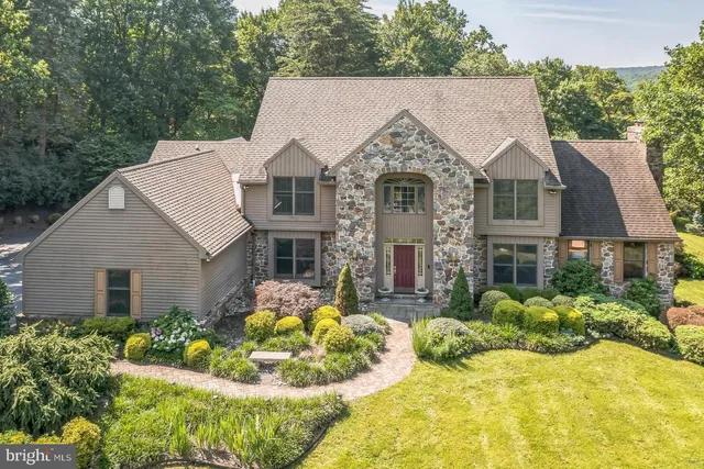 a front view of house with yard and trees around