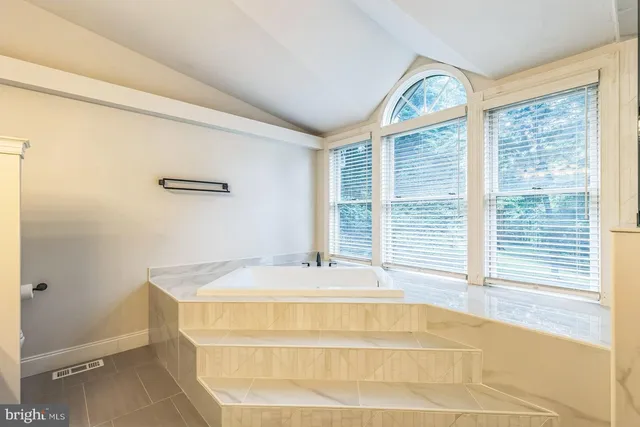 a bath tub sitting in a bathroom next to a window
