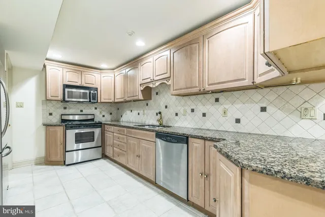 a kitchen with stainless steel appliances granite countertop a sink and cabinets