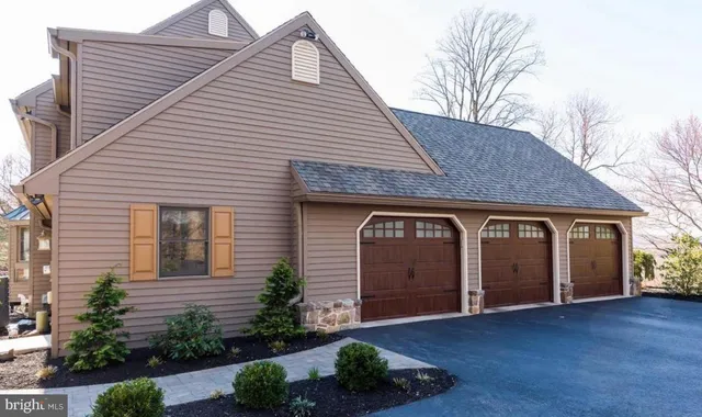a front view of house with yard and trees in the background