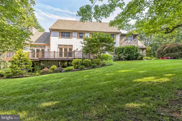 a aerial view of a house next to a big yard and large trees