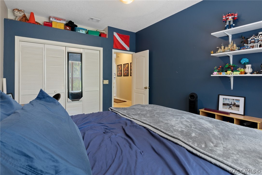 2460 West Pine Ridge Boulevard Beverly Hills, FL 34465 - Photo 34 of 47 a bedroom with a bed and a book shelf