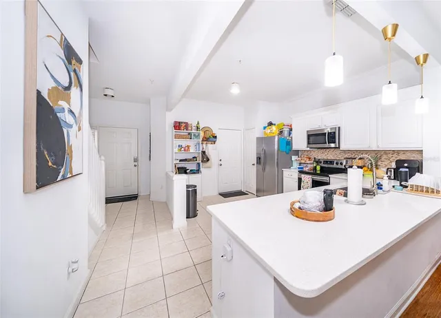 a kitchen with a sink a refrigerator and cabinets