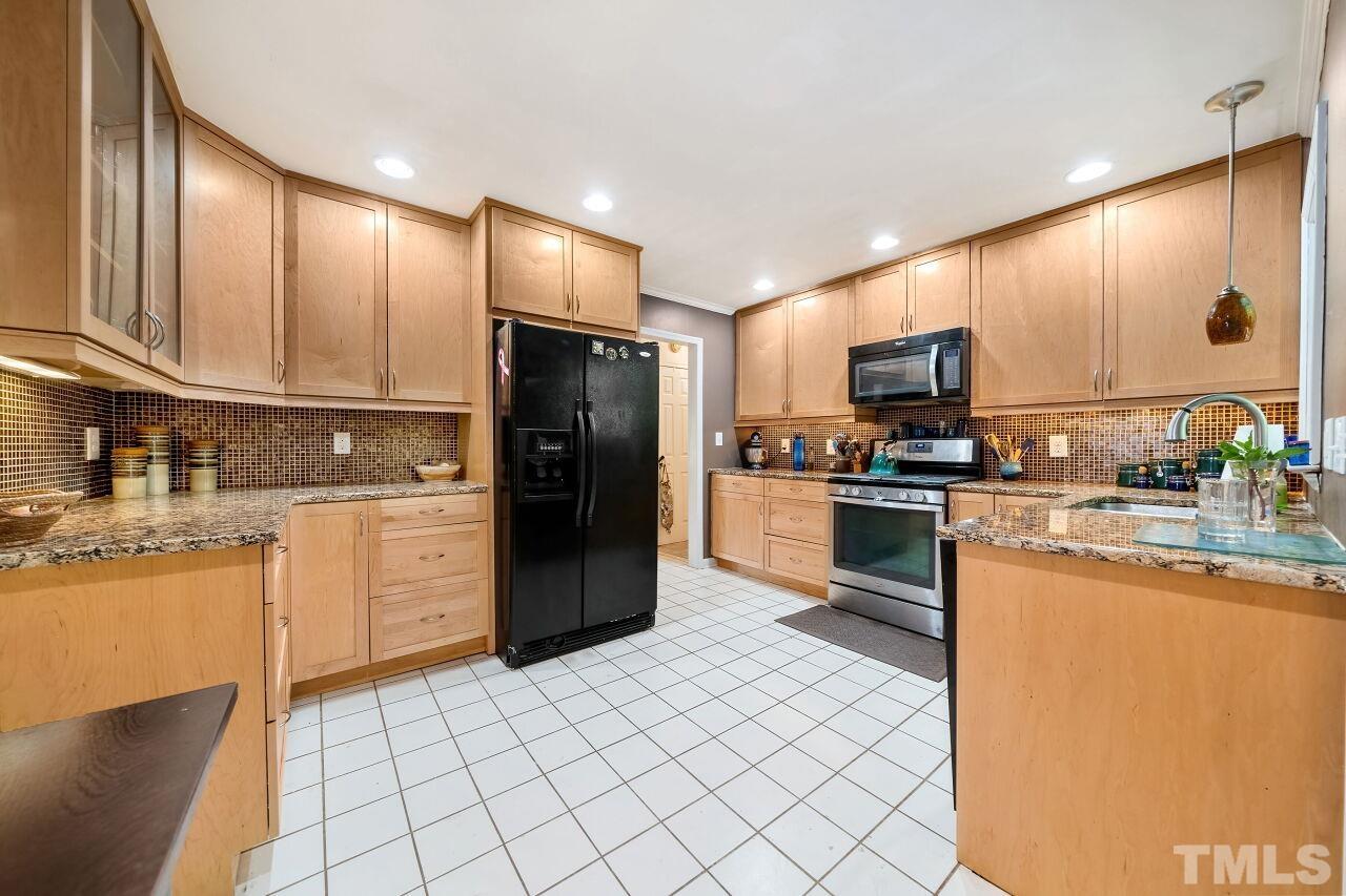 608 Brighton Road Durham, NC 27707 - Photo 8 of 26 a kitchen with stainless steel appliances granite countertop a refrigerator a stove a sink and a microwave