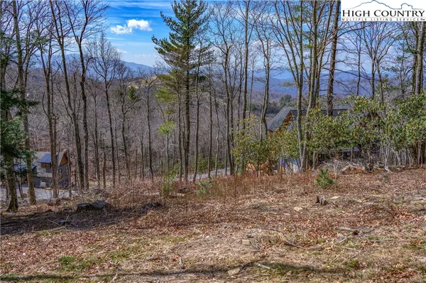 a view of a patio with a dining table and chairs with floor to ceiling window and wooden floor