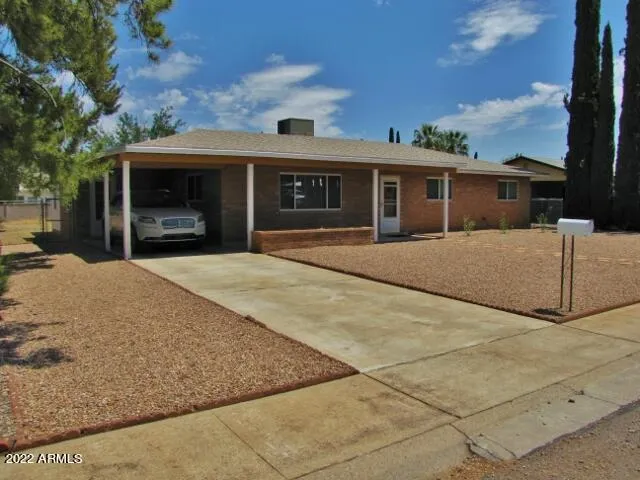 a front view of house with yard and trees in the background