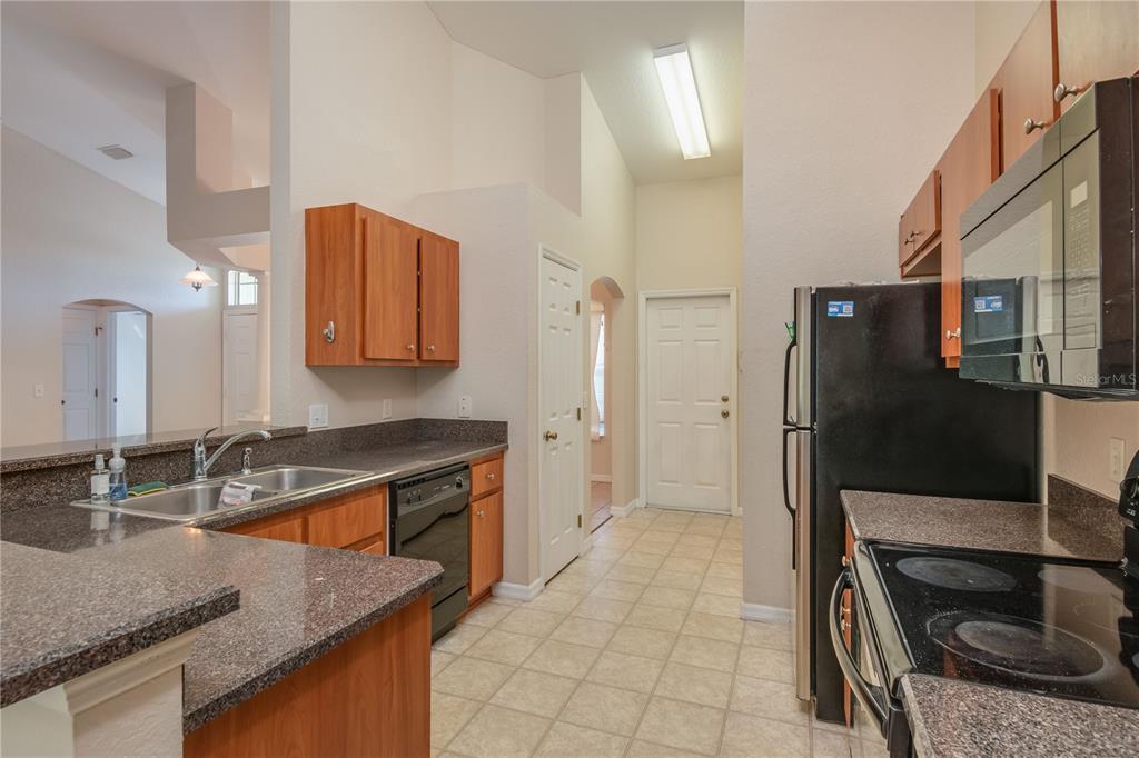 6375 Southwest 63rd Street Ocala, FL 34474 - Photo 14 of 35 a kitchen with a sink refrigerator and microwave