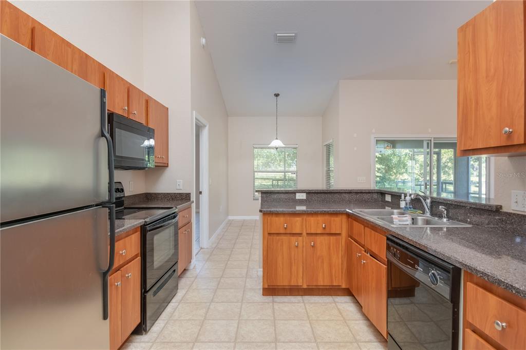 6375 Southwest 63rd Street Ocala, FL 34474 - Photo 15 of 35 a kitchen with stainless steel appliances granite countertop a sink stove and refrigerator